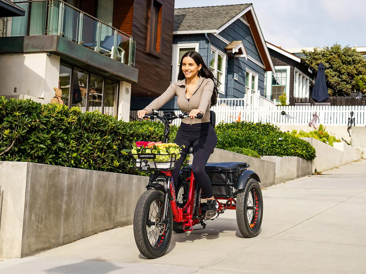 A woman rides an upright tricycle to buy flowers